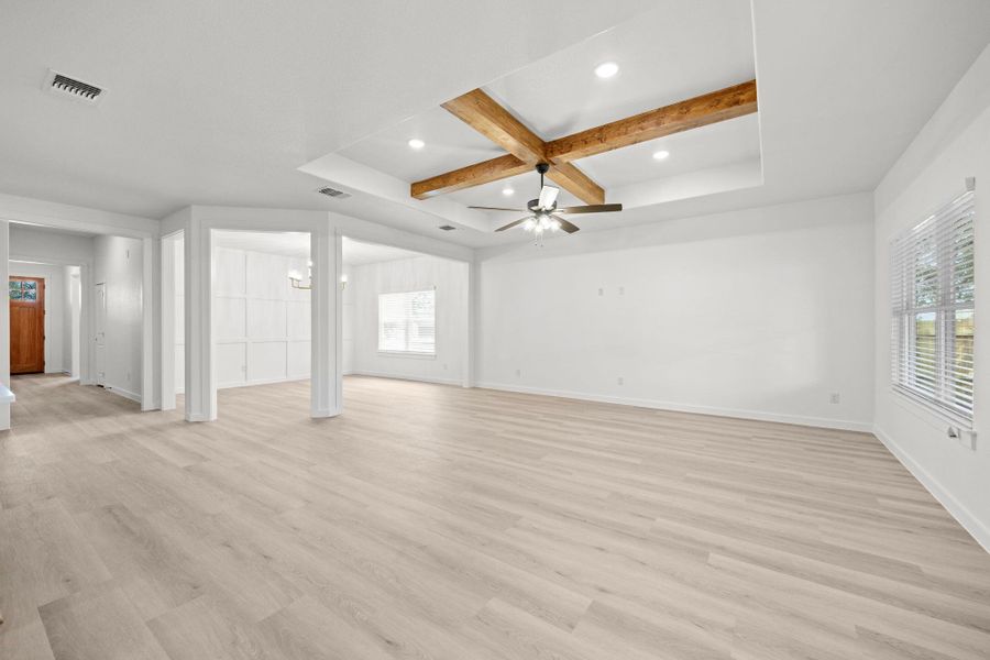An airy living area boasts recessed lighting and rich exposed beams, complemented by light-toned flooring. An airy living area boasts recessed lighting and rich exposed beams, complemented by light-toned flooring.