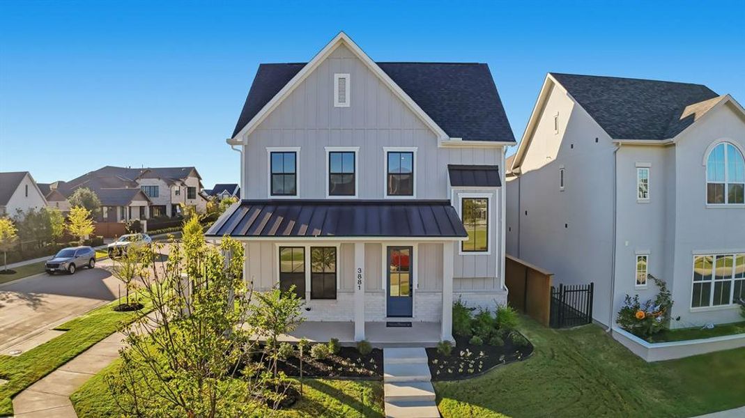 Modern inspired farmhouse with a porch, board and batten siding, a standing seam roof, a metal roof, and a residential view