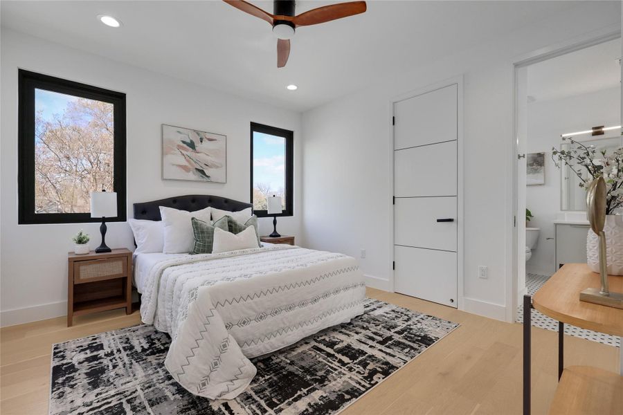 Bedroom with light wood-style flooring, a ceiling fan, recessed lighting, and ensuite bath