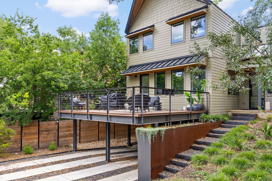 An elevated outdoor patio extends a spacious living area, perfect for entertaining amidst lush landscaping. An elevated outdoor patio extends a spacious living area, perfect for entertaining amidst lush landscaping.