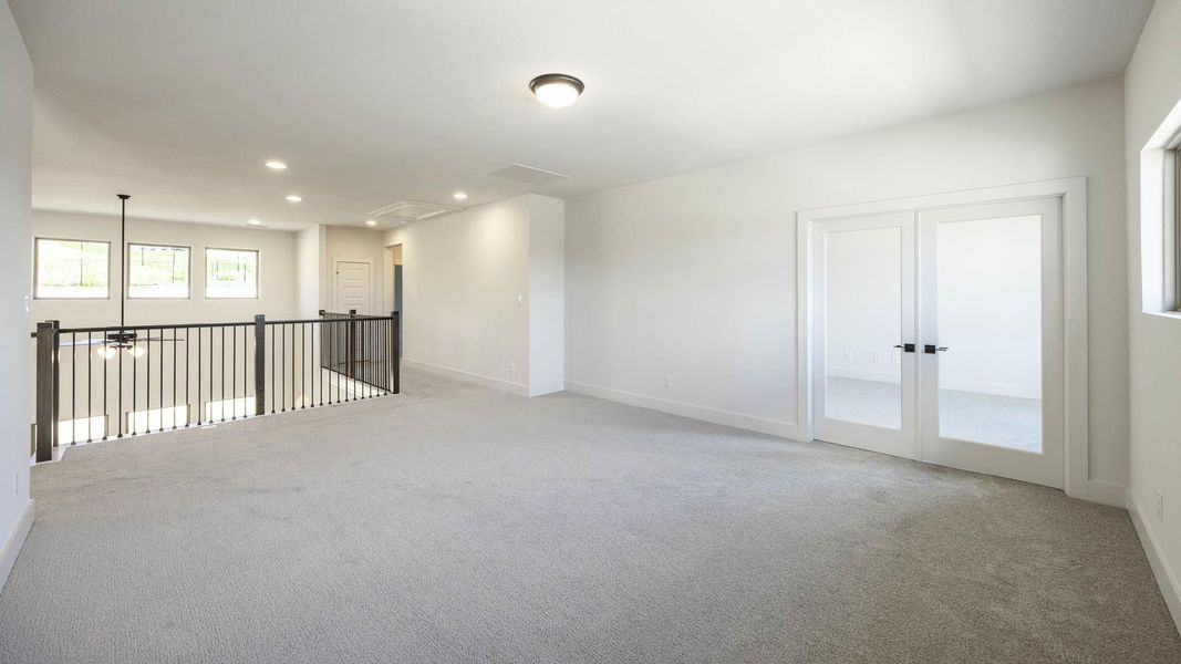 Unfurnished room featuring light colored carpet, recessed lighting, attic access, and french doors