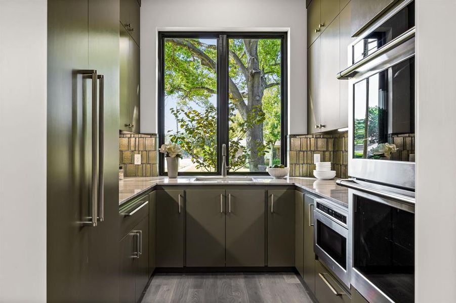 Kitchen featuring appliances with stainless steel finishes, light wood-type flooring, gray cabinets, and decorative backsplash Kitchen featuring appliances with stainless steel finishes, light wood-type flooring, gray cabinets, and decorative backsplash