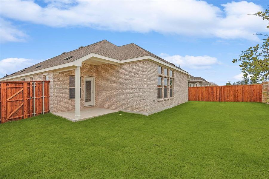 Back of property featuring a lawn and a patio area