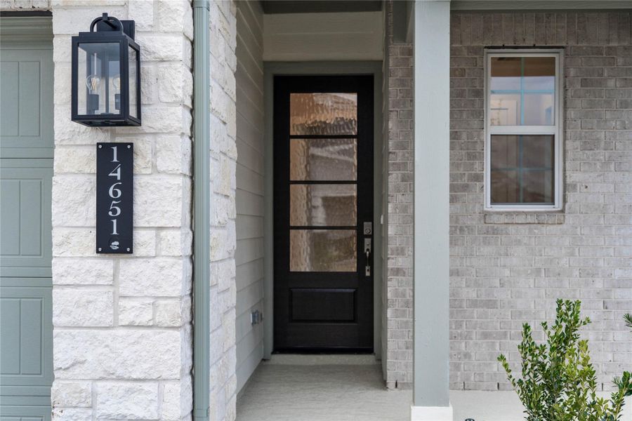 As you walk up to this beautiful home, you notice the stone and brick elevation with modern farmhouse style. The main entry features a sophisticated black door with glass, allowing natural light into the foyer and showcases excellent curb appeal.
