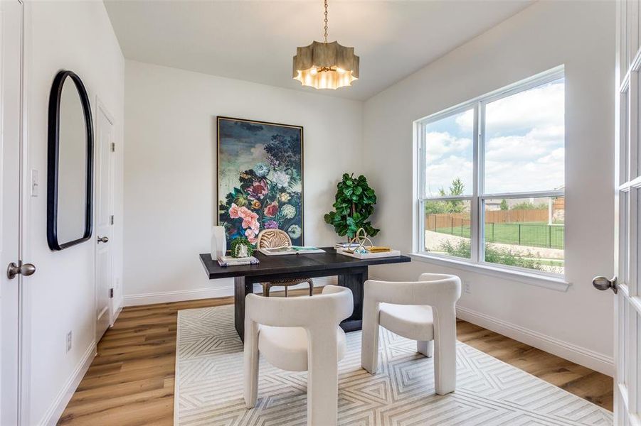 Office space featuring an inviting chandelier and light hardwood / wood-style flooring