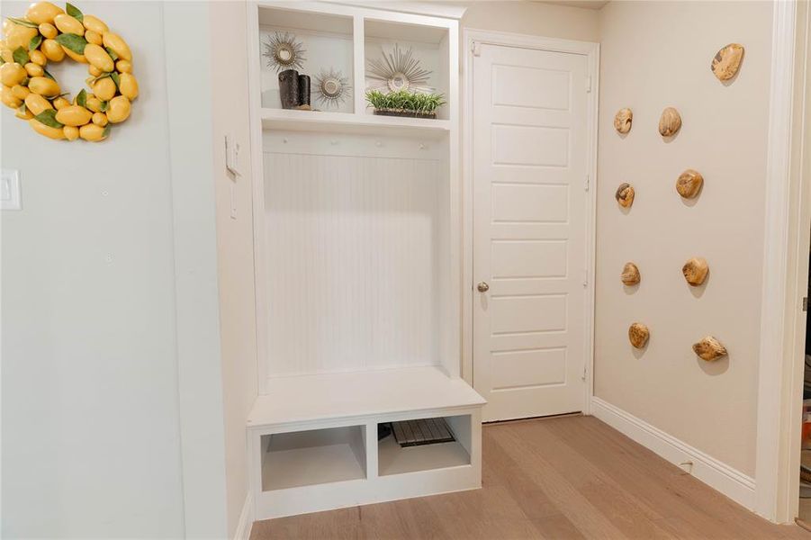 Mudroom featuring light wood-style flooring and baseboards