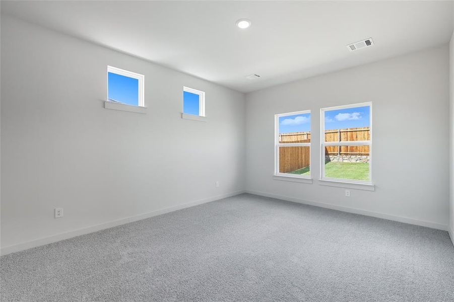 Empty room with healthy amount of natural light, carpet, and recessed lighting Empty room with healthy amount of natural light, carpet, and recessed lighting