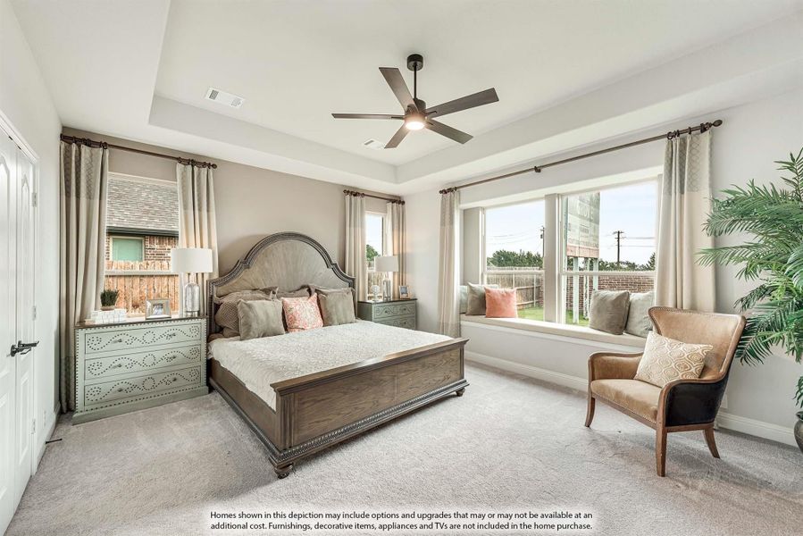 Master bedroom with tray ceiling, ceiling fan, window seat, and carpeted floors
