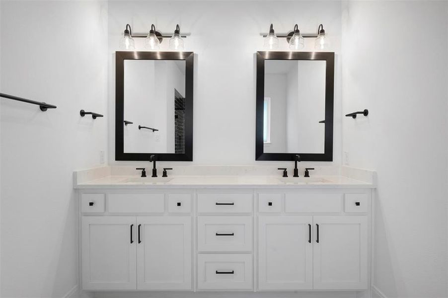 Full bath with double vanity and baseboards