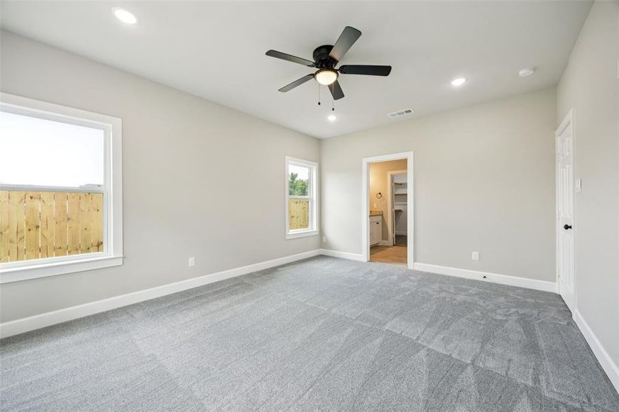 Unfurnished bedroom with carpet flooring, recessed lighting, connected bathroom, and ceiling fan Unfurnished bedroom with carpet flooring, recessed lighting, connected bathroom, and ceiling fan