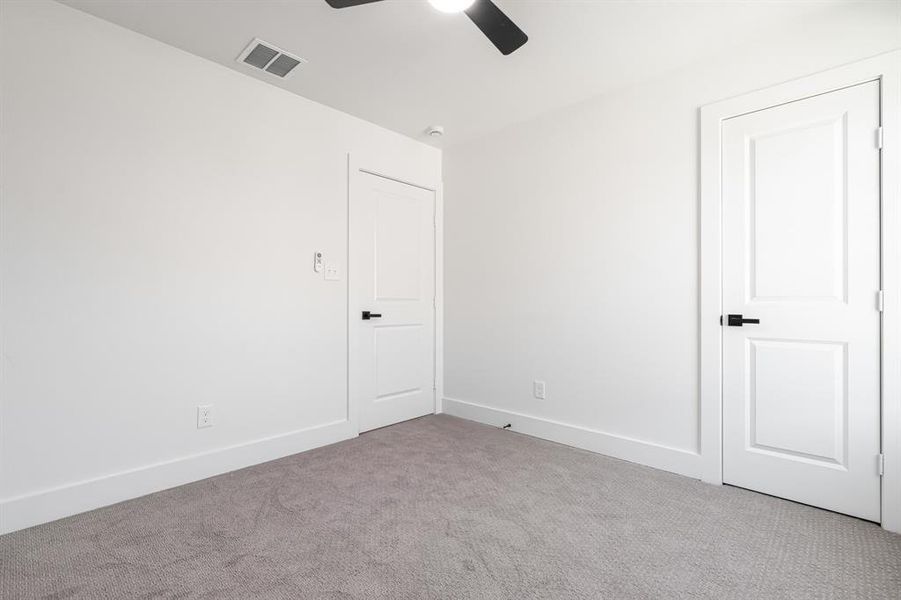Unfurnished bedroom with carpet flooring and a ceiling fan