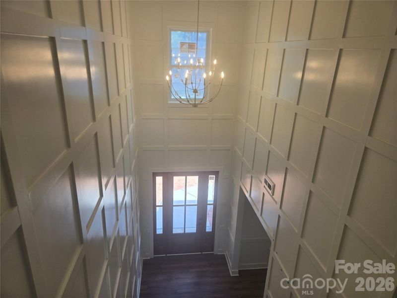 This stunning two-story foyer features exquisite custom woodworking and a dramatic statement light fixture that serves as an elegant focal point. This stunning two-story foyer features exquisite custom woodworking and a dramatic statement light fixture that serves as an elegant focal point.