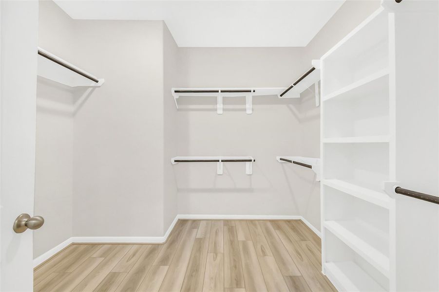 This massive primary closet is a dream for organization, complete with extensive built-in shelving and abundant hanging space.