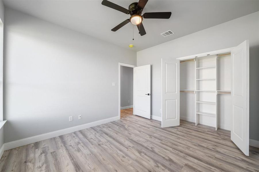 Unfurnished bedroom featuring wood finished floors, a closet, and ceiling fan Unfurnished bedroom featuring wood finished floors, a closet, and ceiling fan