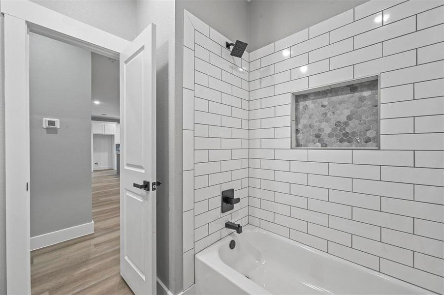 Bathroom featuring wood-type flooring and tiled shower / bath combo