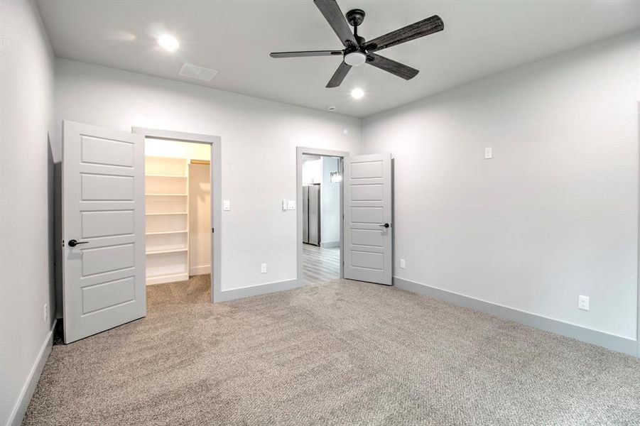 Unfurnished bedroom featuring a spacious closet, light colored carpet, a ceiling fan, and recessed lighting Unfurnished bedroom featuring a spacious closet, light colored carpet, a ceiling fan, and recessed lighting