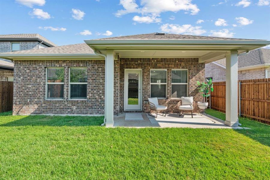 Rear view of property featuring a patio area, brick siding, and roof with shingles Rear view of property featuring a patio area, brick siding, and roof with shingles