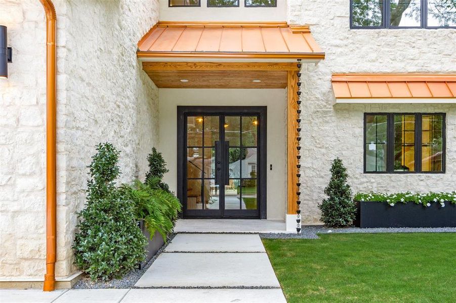 View of exterior entry featuring a standing seam roof, stucco siding, french doors, and a metal roof
