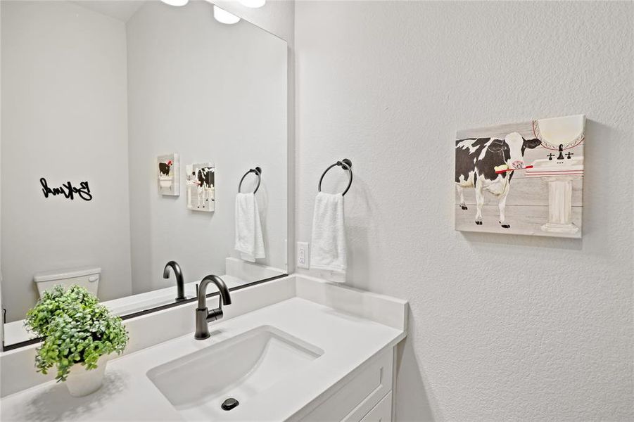 Half bath with vanity and a textured wall Half bath with vanity and a textured wall