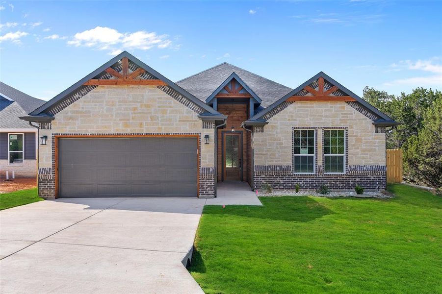 View of front of home with a garage and a front lawn