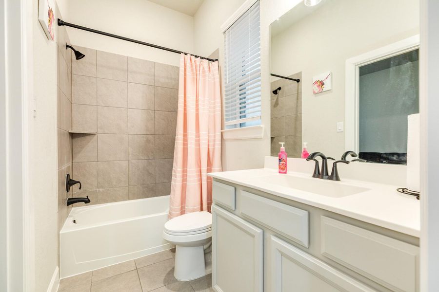 The secondary bathroom, shared by two bedrooms, includes a shower-tub combo.