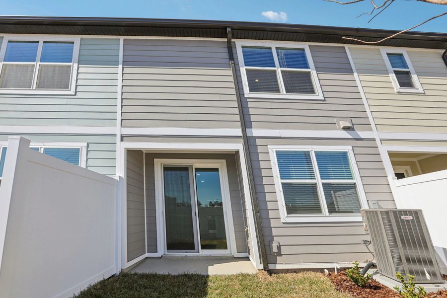 Spacious covered lanai with sliding glass doors at the back of the home