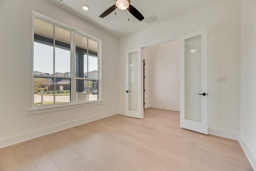 Unfurnished room with light wood-type flooring, french doors, and recessed lighting Unfurnished room with light wood-type flooring, french doors, and recessed lighting