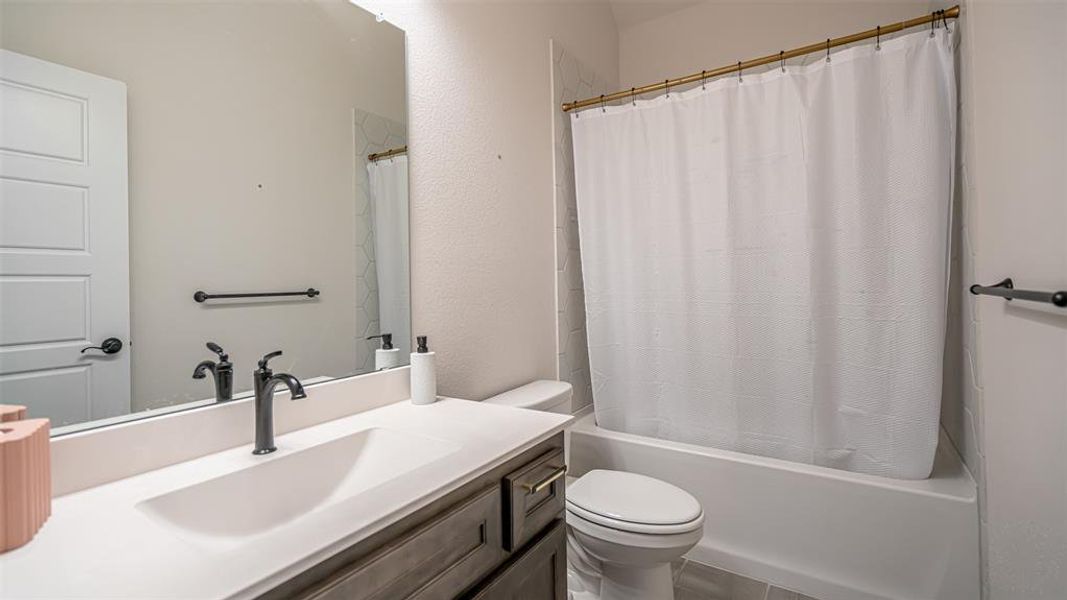 Bathroom featuring a vanity with an integrated sink, matte black faucet, and gray wood-finish cabinetry