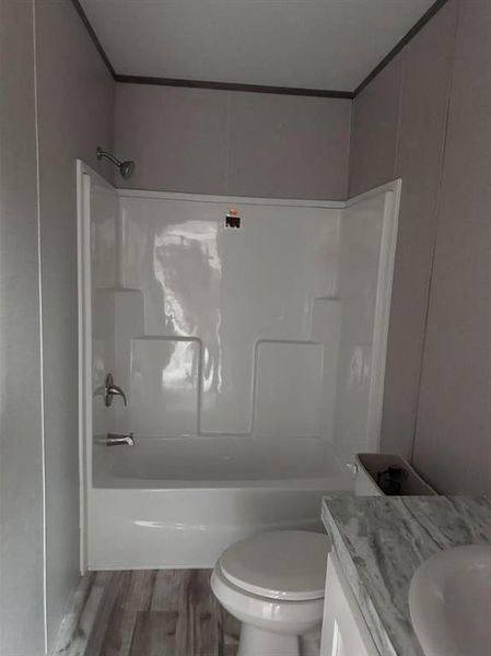 Full bathroom with vanity, wood finished floors, and tub / shower combination Full bathroom with vanity, wood finished floors, and tub / shower combination