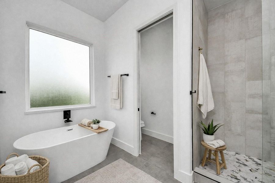 Spa-like primary bathroom retreat featuring a freestanding soaking tub, walk-in shower, and clean modern finishes.