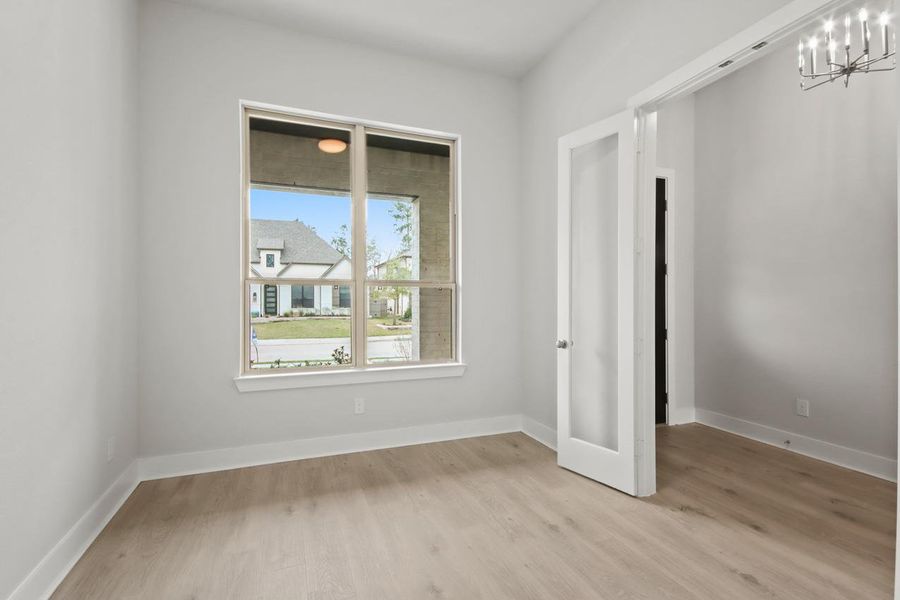 Empty room featuring baseboards, a chandelier, and light wood finished floors Empty room featuring baseboards, a chandelier, and light wood finished floors