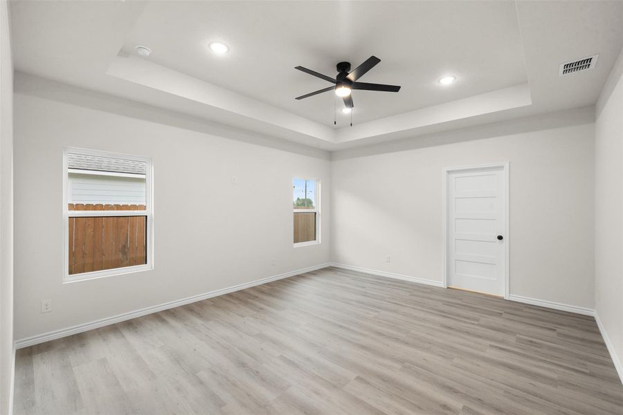 A generously proportioned bedroom with recessed lighting and a stylish ceiling fan. A generously proportioned bedroom with recessed lighting and a stylish ceiling fan.