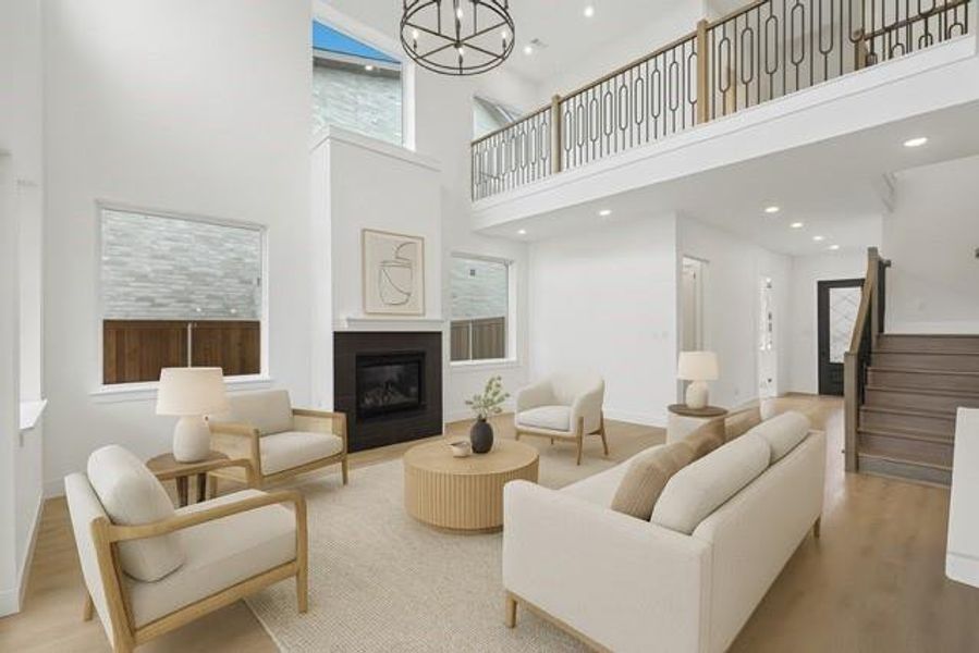 Living room featuring a high ceiling, stairway, wood finished floors, recessed lighting, and a glass covered fireplace virtually staged