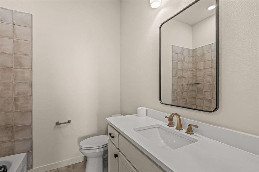 Bathroom with vanity, toilet, a bath, and wood finished floors