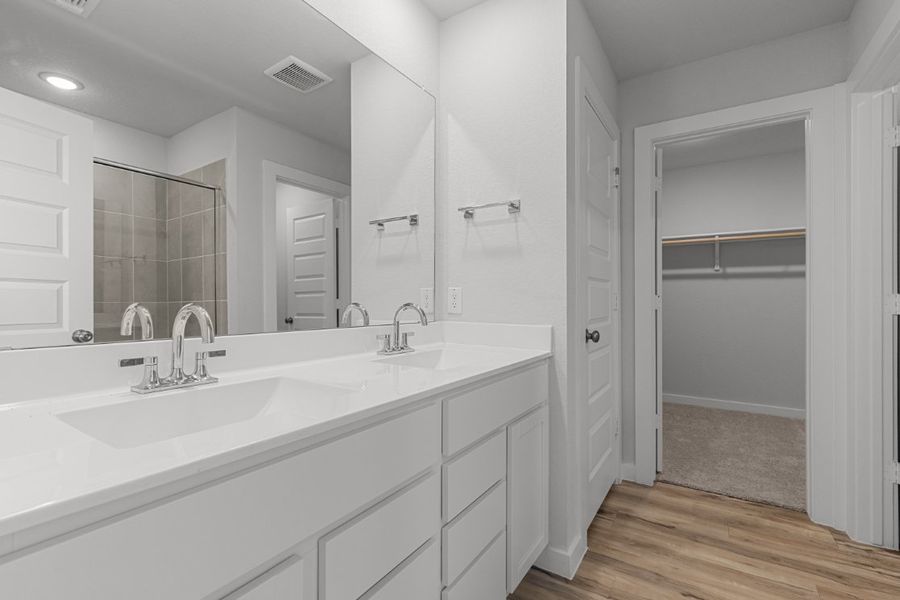 A bathroom with white cabinets.