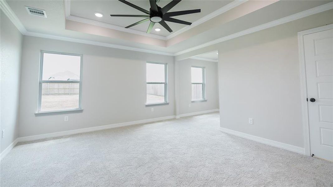Unfurnished room with crown molding, light colored carpet, ceiling fan, recessed lighting, and a raised ceiling Unfurnished room with crown molding, light colored carpet, ceiling fan, recessed lighting, and a raised ceiling