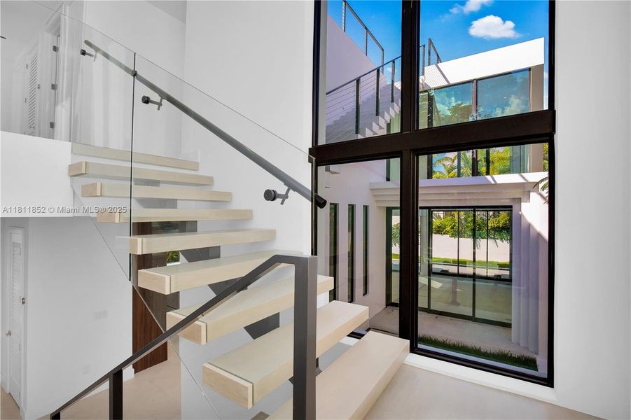 Staircase leading up to the second floor with glass windows on both sides of the staircase Staircase leading up to the second floor with glass windows on both sides of the staircase