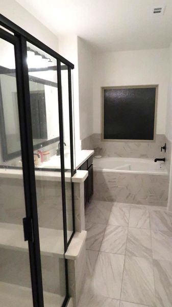 This modern bathroom features a sleek glass-enclosed shower, a spacious bathtub, and elegant tile flooring. The neutral color palette and contemporary fixtures create a clean, inviting space. This modern bathroom features a sleek glass-enclosed shower, a spacious bathtub, and elegant tile flooring. The neutral color palette and contemporary fixtures create a clean, inviting space.