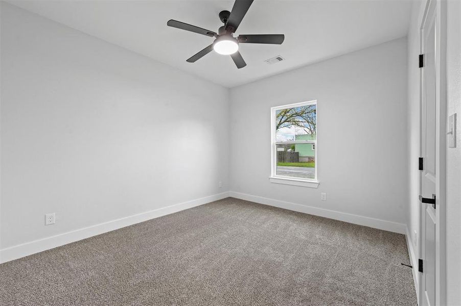 Carpeted spare room with ceiling fan