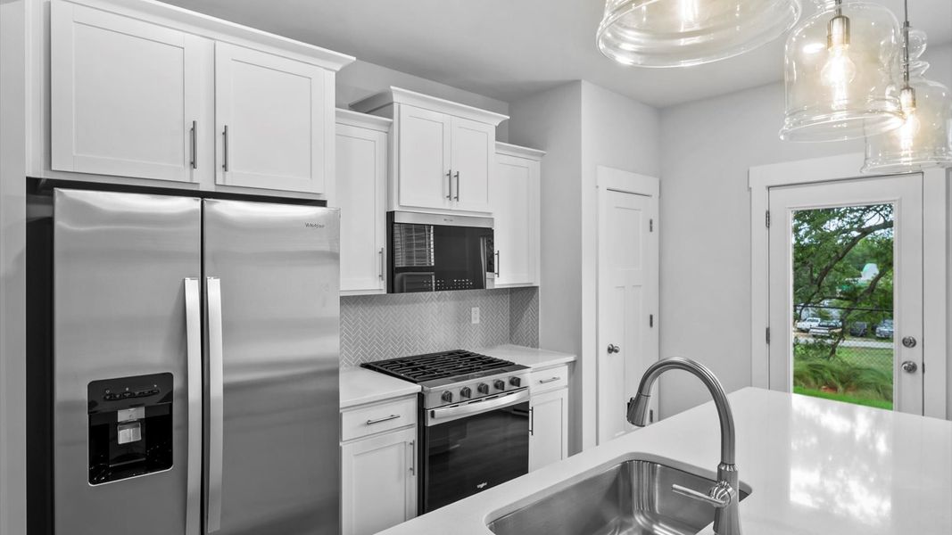 Highly skilled kitchen design includes a 9-foot island, quartz countertops, and stylish pendant fixtures in Piedmont, SC