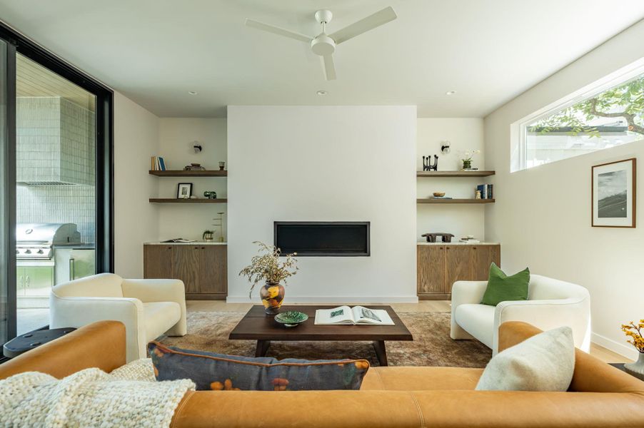 A modern fireplace is flanked by custom wood built-ins in this open living space. A modern fireplace is flanked by custom wood built-ins in this open living space.