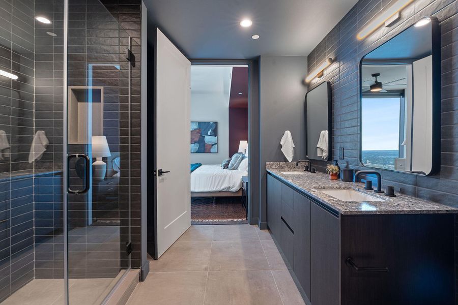 Representative Photo. Primary Bath with spacious double vanity, floor to ceiling tile, and a walk in shower
