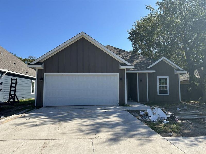 Ranch-style home with board and batten siding, concrete driveway, an attached garage, and roof with shingles Ranch-style home with board and batten siding, concrete driveway, an attached garage, and roof with shingles