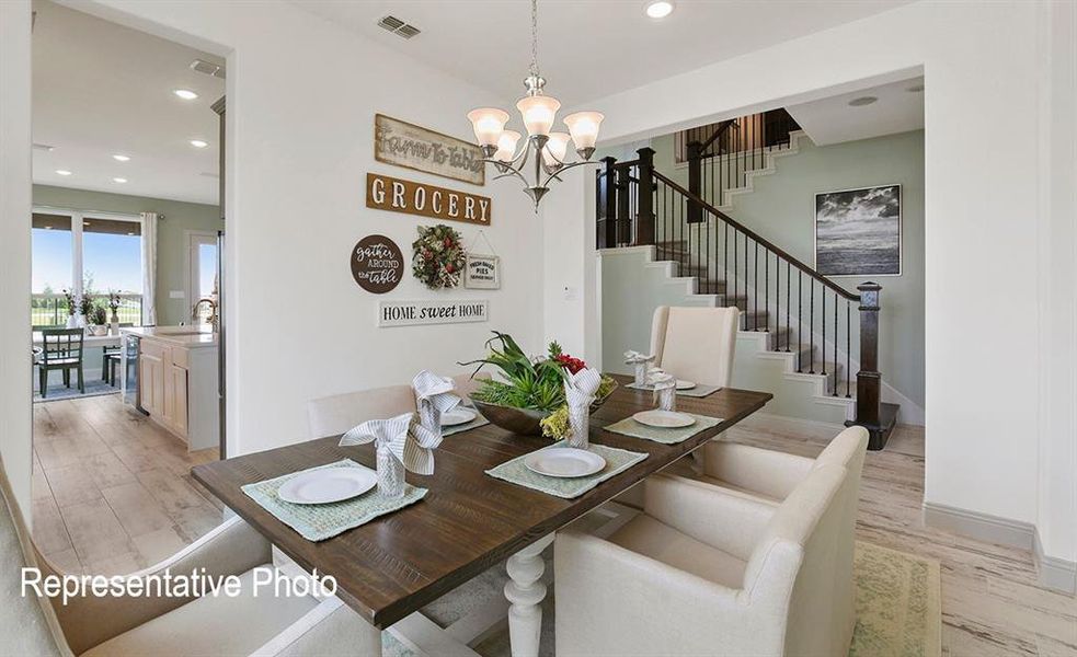 Dining space featuring a chandelier, sink, and light hardwood / wood-style flooring