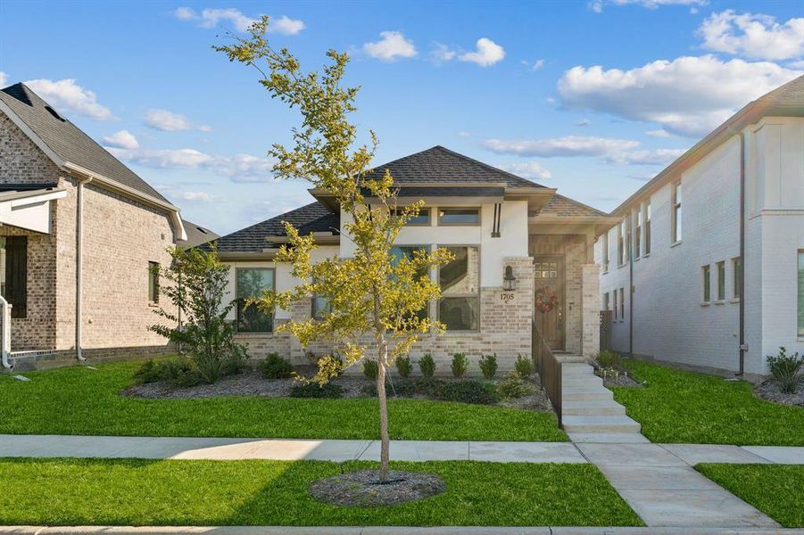 View of front facade featuring a front yard, brick siding, and roof with shingles View of front facade featuring a front yard, brick siding, and roof with shingles