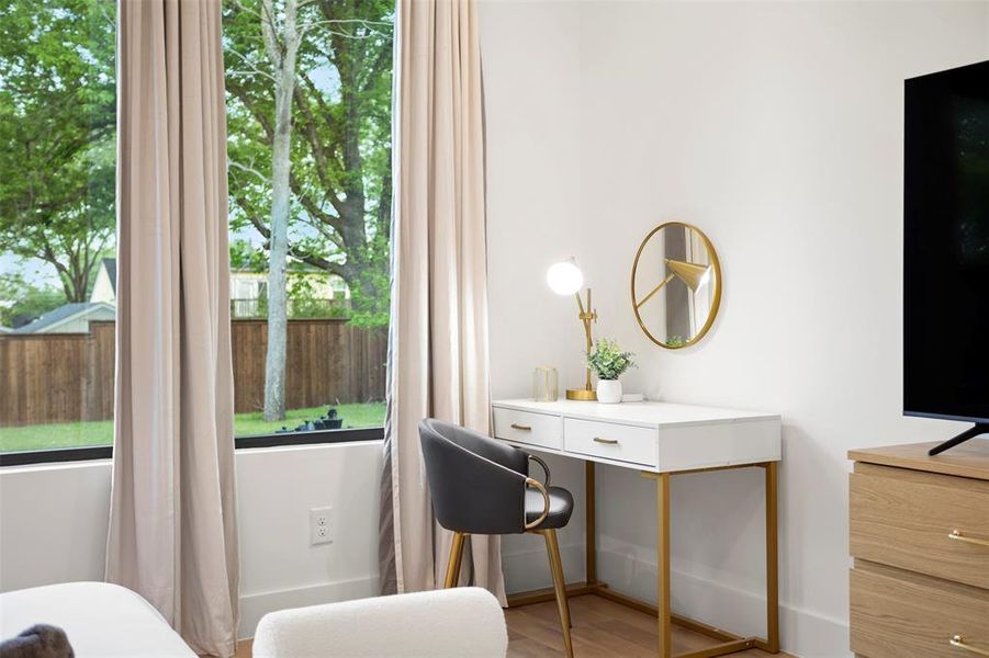 Large window with neutral drapes, wood-finish flooring, white walls, and a wood-finish dresser