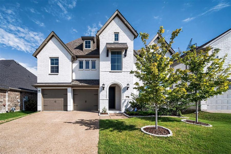 View of front facade with a front lawn, brick siding, driveway, an attached garage, and roof with shingles View of front facade with a front lawn, brick siding, driveway, an attached garage, and roof with shingles