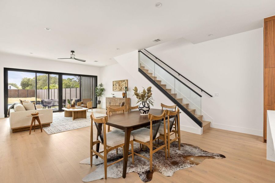 Hardwood floors and generous natural light define this welcoming open-concept living and dining area.
