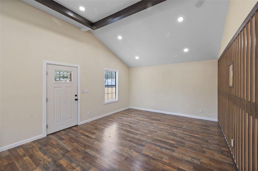 Foyer entrance featuring beam ceiling, dark hardwood / wood-style flooring, and high vaulted ceiling