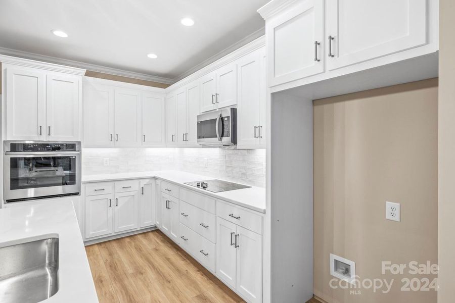 Wall oven, quartz countertops and tile backsplash